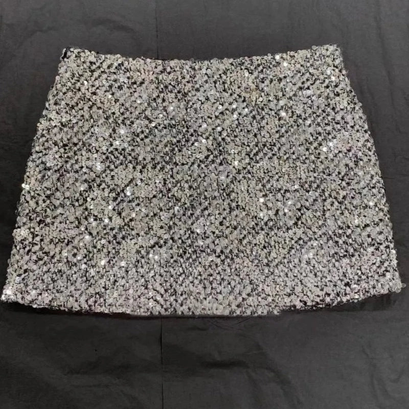 Faltenrock und Rollkragenpullover mit Pailletten und Strass