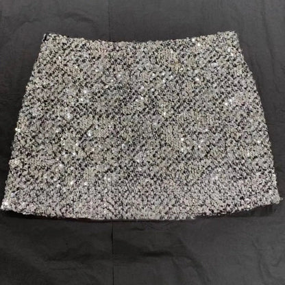Faltenrock und Rollkragenpullover mit Pailletten und Strass